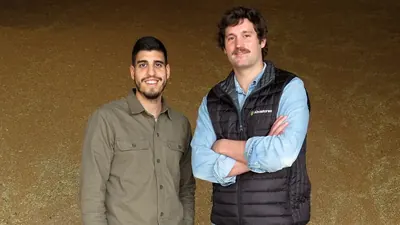 Two members of the Abastores team in front of a pile of grain