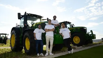 Members of the Abastores team next to a tractor in the field