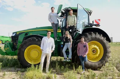 Members of the Abastores team next to a tractor in the field